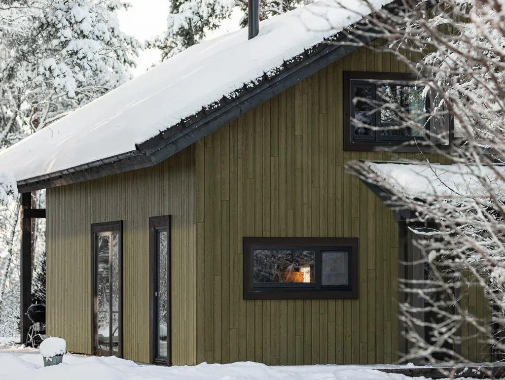 Custom colored cladding with Vivid by Thermory on home in winter