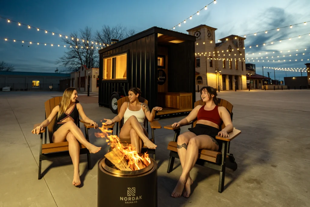 3 friends enjoying a fire after a sauna session
