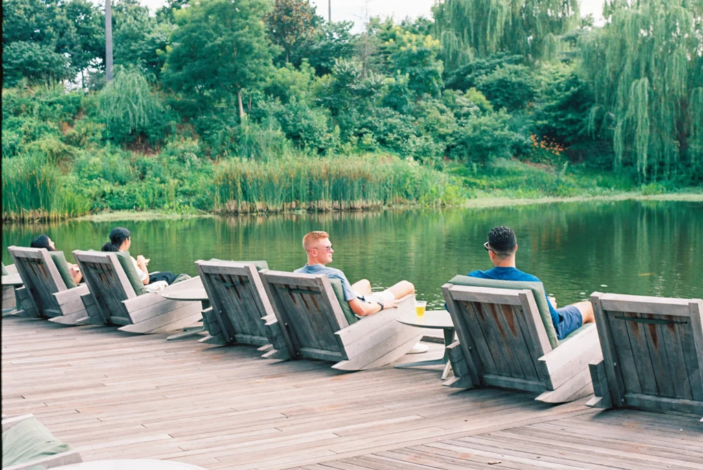 people lounging at the gathering place in Tulsa in front of pond